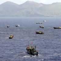 Boats operated by Chinese coral poachers dot the ocean near the Ogasawara Islands, south of Tokyo, on Oct. 31. | KYODO