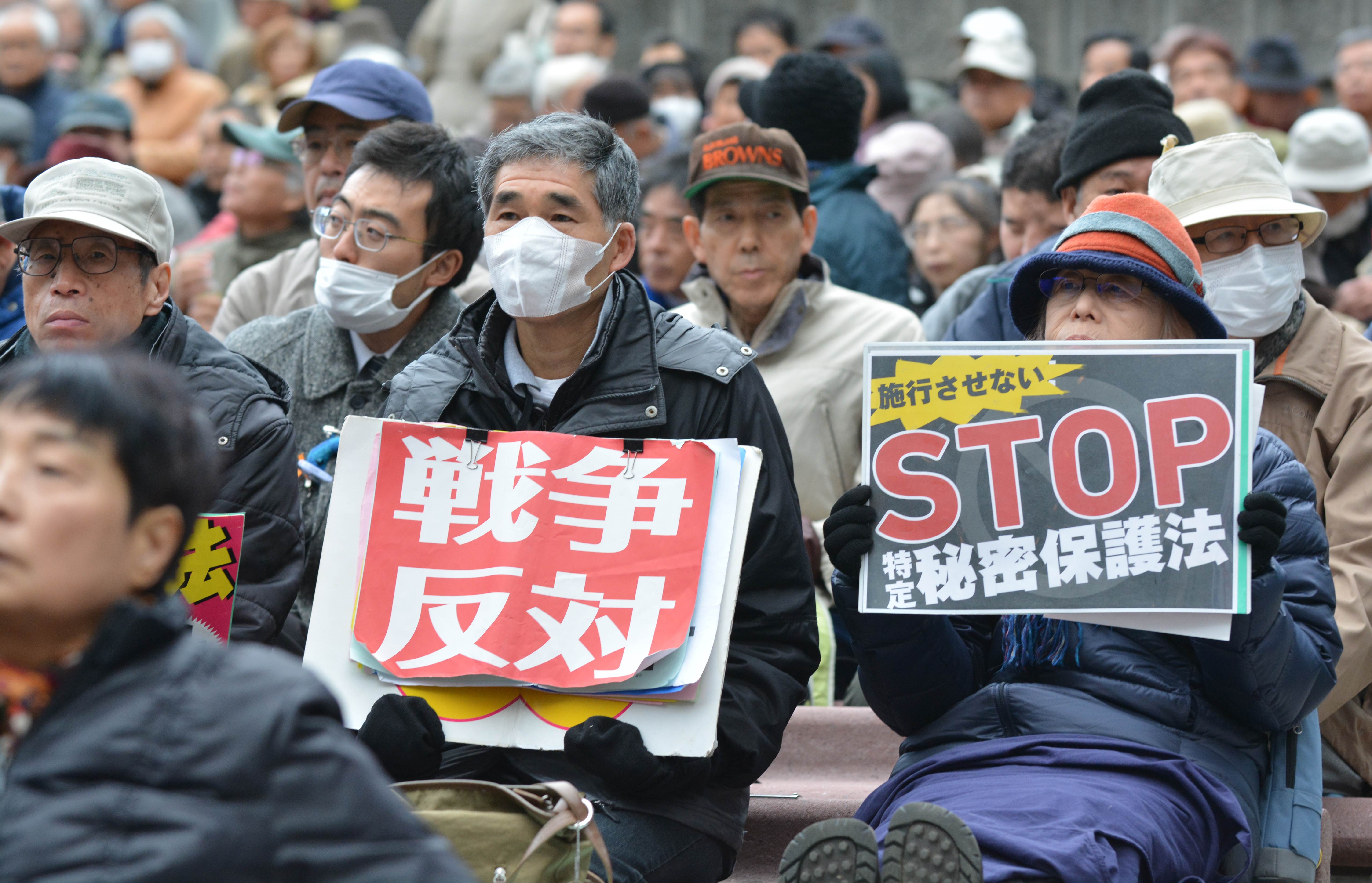 Protesters hold signs reading, from right, 'Stop secrets protection law' and 'Oppose war' during a rally in Tokyo on Saturday. The law took effect on Wednesday. | AFP-JIJI