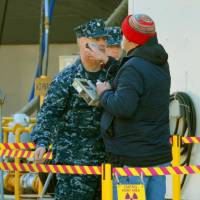 A U.S. Navy officer receives a radiation check Wednesday at the Yokosuka base during a joint nuclear drill. | KYODO