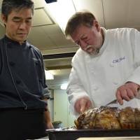 Fine cut: Old Nic carves a haunch of venison alongside hotel head chef Makoto Ozawa at the El Bosco Nojiri Lake Hotel in Nagano Prefecture. | COURTESY OF C.W. NICOL