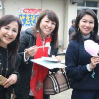 For the children: Divina Liza Sato (center) and other JOYFUL volunteers attend a fund-raising event. Group offers free English to kids in care in Japan and aid to children in Philippines