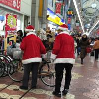 Santas pitch in as bike attendants in a Tokyo shopping arcade. | © 2013 Tomura Gallery