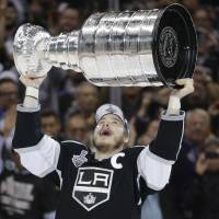 Dustin Brown of the Los Angeles Kings lifts the Stanley Cup in June. | AP