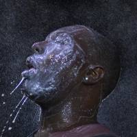 A man is doused with milk and sprayed with mist after his eyes were affected by a chemical irritant used by police attempting to control riots in Ferguson, Missouri, on Aug. 20. | REUTERS