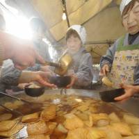 Women boil slices of \"daikon\" (radish) together with pieces of deep-fried tofu in a huge pot at Kyoto\'s Daihoon-ji Temple during an annual event that started Sunday. Visitors eat the contents while simultaneously praying for good health in the coming year. | KYODO