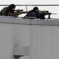 French special forces sharp shooters take position on a rooftop of the complex at the scene of a hostage taking Friday at an industrial zone in Dammartin-en-Goele, northeast of Paris. | REUTERS