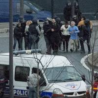 Security officers escort released hostages Friday after they stormed a kosher market to end a hostage situation. Explosions and gunshots were heard as police forces stormed a kosher grocery in Paris where a gunman was holding at least five people hostage.  | AP