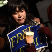 A woman sheds a tear during a quiet demo calling for the release of Islamic State captive Kenji Goto on Wednesday evening in front of the prime minister\'s office. | FINBAR O\'MALLON