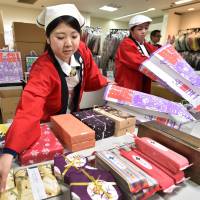 Employees of a department store place products into \"lucky bags\" for their new year sale in Tokyo on Dec. 26. | AFP-JIJI