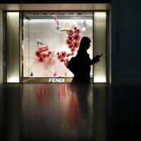 A pedestrian walks past a display of Fendi SpA products outside a department store in Tokyo. Government data released on Thursday show retail sales unexpectedly fell in December, underscoring challenges to Prime Minister Shinzo Abe\'s economic policies. | BLOOMBERG