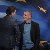 Dutch Finance Minister and Eurogroup President Jeroen Dijsselbloem (left) talks to Greek Finance Minister Yanis Varoufakis as he leaves following a joint news conference after their meeting at the Finance Ministry in Athens on Friday. | AP
