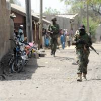 Soldiers walk through the remote northeast Nigeria town of Baga in Borno State in April 2013. Boko Haram launched renewed attacks around Baga this week, razing at least 16 towns and villages, a local government and a union official told AFP on Thursday. | AFP-JIJI