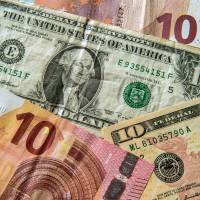 Euros and dollar bills are arranged for a photo in Lille, France, on Saturday as the euro fell against the dollar on growing speculation the European Central Bank will act to jump-start the ailing eurozone economy. | AFP-JIJI