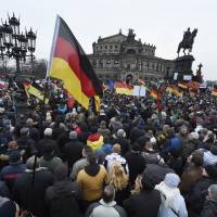 Demonstrators wave flags during a rally organized by the Patriotic Europeans Against the Islamization of the West (PEGIDA) in Dresden, Germany, on Sunday. | AP