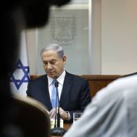 Israeli Prime Minister Benjamin Netanyahu attends a weekly Cabinet meeting at his office in Jerusalem on Sunday. His decision to accept an invitation to address the U.S. Congress just days before Israel\'s parliamentary election offers him invaluable pre-vote publicity, but may also have shaken the balance of U.S.-Israeli ties. | REUTERS