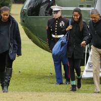 U.S. President Barack Obama arrives Sunday with his family, including first lady Michelle Obama (left) and daughter Malia (second right), via the chopper Marine One on the South Lawn of the White House. Obama returned to Washington after spending the Christmas and New Year holidays in his home state of Hawaii. | REUTERS