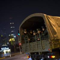 Paramilitary police Thursday sit on a truck leaving the location where people were killed in fatal crush during a New Year\'s celebration on the Bund in Shanghai. | REUTERS