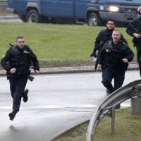 Members of the French gendarmerie intervention forces arrive at the scene of a hostage taking at an industrial zone in Dammartin-en-Goele, northeast of Paris. The two main suspects in the weekly satirical newspaper Charlie Hebdo killings were sighted on Friday in the northern French town of Dammartin-en-Goele where at least one person had been taken hostage, a police source said. | REUTERS