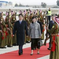 Prime Minister Shinzo Abe and his wife, Akie, are greeted by an honor guard at Queen Alia International Airport in the Jordanian capital of Amman on Saturday after flying from Cairo. Abe is on a six-day Middle East trip. | KYODO