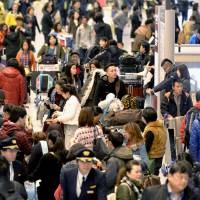 Tourists swarm the arrival lobby at Narita International Airport east of Tokyo on Dec. 25. | KYODO