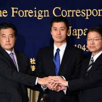 Candidates for the DPJ leadership (from left) Katsuya Okada, Goshi Hosono and Akira Nagatsuma join hands at the Foreign Correspondents\' Club of Japan in Tokyo on Thursday. | AFP-JIJI
