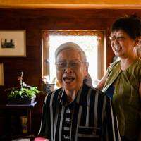 A woman diagnosed with Alzheimer\'s disease almost 10 years ago shares a laugh with her daughter in their apartment in Osaka on Aug. 6. The government estimates that about 7 million people aged 65 or older will be suffering from dementia in Japan by 2025. | BLOOMBERG