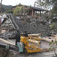 Police inspect a demolished film set where a worker died in an accident at a film lot during preparations for the shooting of a new Martin Scorsese movie titled \"Silence,\" in Taipei, Taiwan. One construction worker was killed and two others were injured after scaffolding around a building being torn down suddenly collapsed, according to Taiwan\'s Central News Agency. | AP