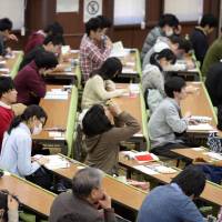 Students take unified college entrance examinations Saturday at the University of Tokyo in Bunkyo Ward. | KYODO