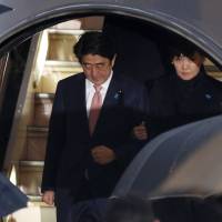 Prime Minister Shinzo Abe and his wife, Akie, disembark from a plane at Tokyo\'s Haneda airport on Wednesday. | REUTERS