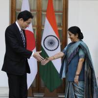 Foreign Minister Fumio Kishida and Indian Foreign Minister Sushma Swaraj greet each other before the start of a meeting n New Delhi on Saturday. | AP