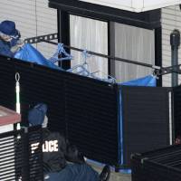 Police investigate the apartment of a 19-year-old female college student Tuesday in Showa Ward, Nagoya, after the body of an elderly woman was found there. | KYODO