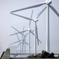 Wind turbines tower over a renewable energy facility in Kamisu, Ibaraki Prefecture, in August 2011. | BLOOMBERG
