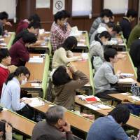 Students take the unified college entrance examinations at the University of Tokyo\'s Hongo campus Saturday. Across Japan, about 560,000 applicants and a record 849 public and private institutions took part. | KYODO