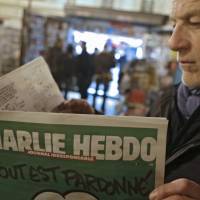 Cover story: A man reads the latest issue of Charlie Hebdo by a newsstand in Nice, southeastern France. The deadly terrorist attack on the office of the satirical magazine &#8212; and the publication\'s defiant response &#8212; have sparked debate in Japan as elsewhere about the limits of free speech. | AP