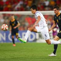 Flying high: South Korea\'s Kwak Tae-hwi moves for the ball against Australia\'s Tomi Juric in their Asian Cup match in Brisbane on Saturday night. South Korea won 1-0. | AFP-JIJI