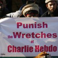 I\'m not Charlie: A man in Pakistan holds a sign during a protest against satirical French weekly newspaper Charlie Hebdo. | REUTERS
