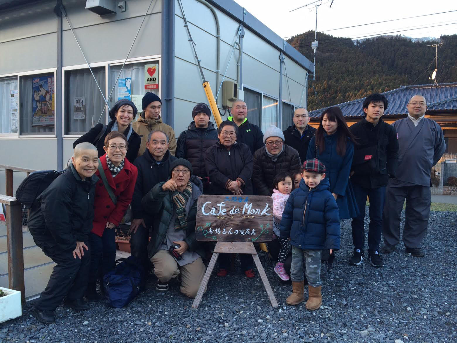 Broken but together: A photo outside Cafe De Monk in Minamisanriku's temporary-housing community after the 3/11 disaster. Mockett's son Ewan stands in front of various people in Mockett's book, 'Where the Dead Pause, and the Japanese say Goodbye.' Mockett herself is at the back on the far left, standing behind her mother. | MARIE MUTSUKI MOCKETT