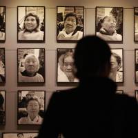 Inconvenient details: A visitor looks at portraits of late former “comfort women” at the House of Sharing, a nursing home for wartime sex slaves in Gwangju, South Korea. There are only a few dozen women left who are registered with the South Korean government as former sex slaves of the Japanese military — down from a peak of more than 230. Their average age is 89. Never mind the facts — logic alone demolishes 'comfort women' deniers' case