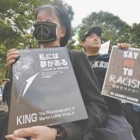 Keeping the dream alive: People hold placards against racism at a demonstration in Tokyo in September 2013. Some 2,000 people took part in an anti-discrimination rally to commemorate the 50th anniversary of the March on Washington and Martin Luther King Jr.\'s \"I have a dream\" speech on Aug. 28, 1963. | AFP-JIJI