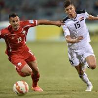 Fight for it: Ahmed Yaseen Gheni of Iraq (right) and Palestine\'s Jaka Hbaisha vie for the ball during their Group D match at the AFC Asian Cup in Canberra, Australia, on Tuesday. Iraq beat Palestine 2-0. | AFP-JIJI