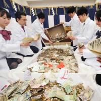 Bank employees count New Year\'s donations at Fushimi Inari Shrine in Fushimi Ward, Kyoto, on Sunday. It will take about five days to count the offerings made by visitors during the first three days of the year. | KYODO
