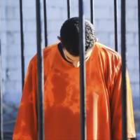 A man purported to be Islamic State captive Jordanian pilot Muath al-Kasaesbeh is seen standing in a cage in this still image from an undated video filmed from an undisclosed location made available on social media on Tuesday. | REUTERS