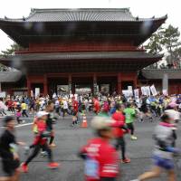 Tokyo Marathon competitors run past Zojoji Temple near Shibakoen in Tokyo\'s Minato Ward on Sunday. | AP