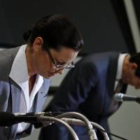 McDonald\'s Holdings Co. (Japan) President and Chief Executive Officer Sarah Casanova (left) bows in apology during a news conference at the Tokyo Stock Exchange on Thursday as McDonald\'s Corp.\'s Japanese affiliate reported its first full-year loss in 11 years. | REUTERS