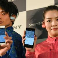 Models show off Sony\'s new Smart B-Trainer SSE-BTR1, a wearable gadget for runners, at a press conference in Tokyo on Thursday. The device combines a music player with six sensors that monitor metrics like heart rate and running pace. | AFP-JIJI