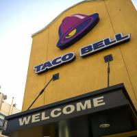 The Taco Bell Corp. logo is displayed on the facade of a restaurant in San Francisco in 2013. The major U.S. fast food chain will reopen restaurants in Japan, with the first outlet expected to open in central Tokyo by this fall. | BLOOMBERG