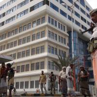 Members of the Popular Resistance Committees (PRC), pro-army tribesmen who maintain security in their region, stand guard outside the state broadcaster complex after they seized it from police allegedly controlled by Shiite Huthi militiamen in the southern Yemeni city of Aden on Monday. Four people were killed when the PRC attacked special police guarding the complex, sparking fighting that lasted until dawn, PRC chief Hussain al-Wuhayshi said. | AFP-JIJI