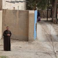 An Iraqi man stands in the village of Fadhiliyah, which pro-government forces retook from Islamic State militants the previous month, on the road leading to Fallujah, in Iraq\'s flashpoint Anbar province, southwest of Baghdad, on Tuesday. The government forces lost control of parts of Anbar\'s provincial capital Ramadi and all of Fallujah at the beginning of 2015 to anti-government fighters. Baghdad on Tuesday suffered a wave a deadly bomb attacks. | AFP-JIJI