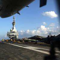French aircraft sit on the flight deck of the French Navy aircraft carrier Charles de Gaulle operating in the Persian Gulf on Monday. | AFP-JIJI