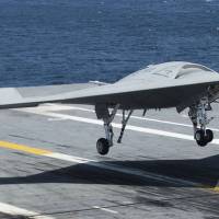 An X-47B Unmanned Combat Air System drone, designed for carrier-based operations, makes its first carrier landing aboard the USS George H.W. Bush in the Atlantic Ocean off Norfolk, Virginia, on July 10, 2013. | AFP